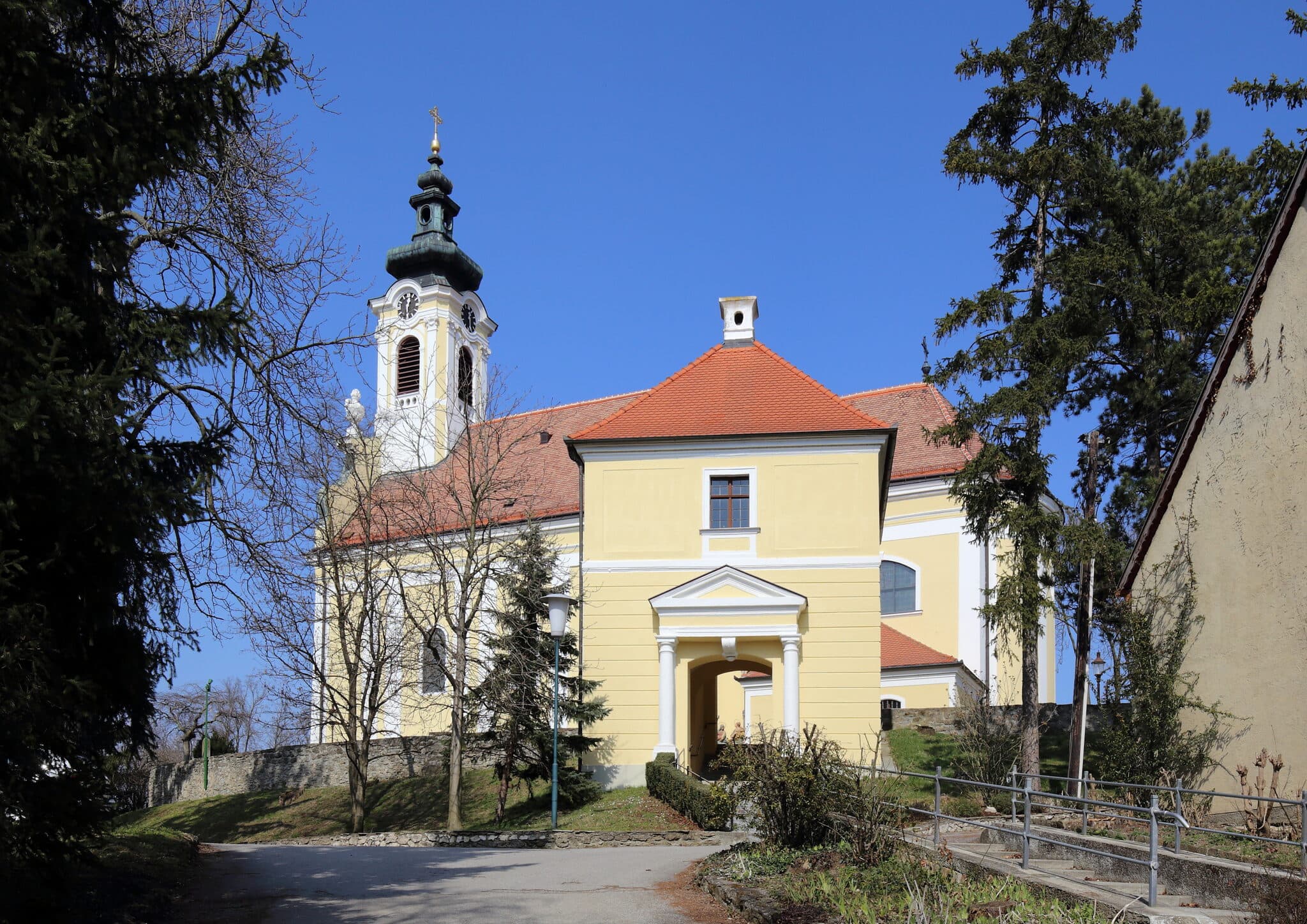Pfarrkirche Bad Pirawarth, Frontansicht mit einladendem Weg und Garten