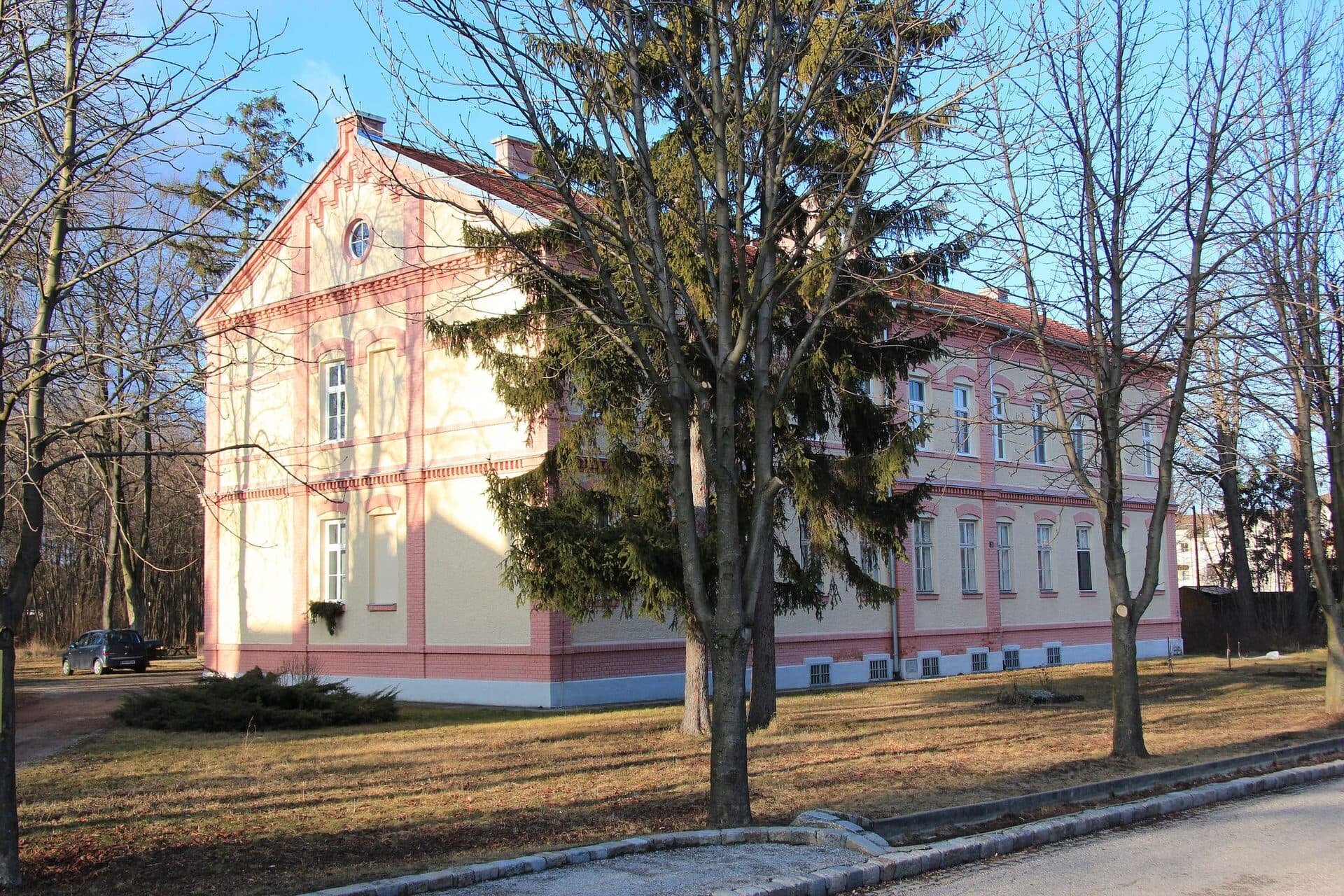 Repraesentatives historisches Gebaeude (Villa) mit gepflegtem gruenen Rasen und Baeumen in Blumau – blumau neurisshof