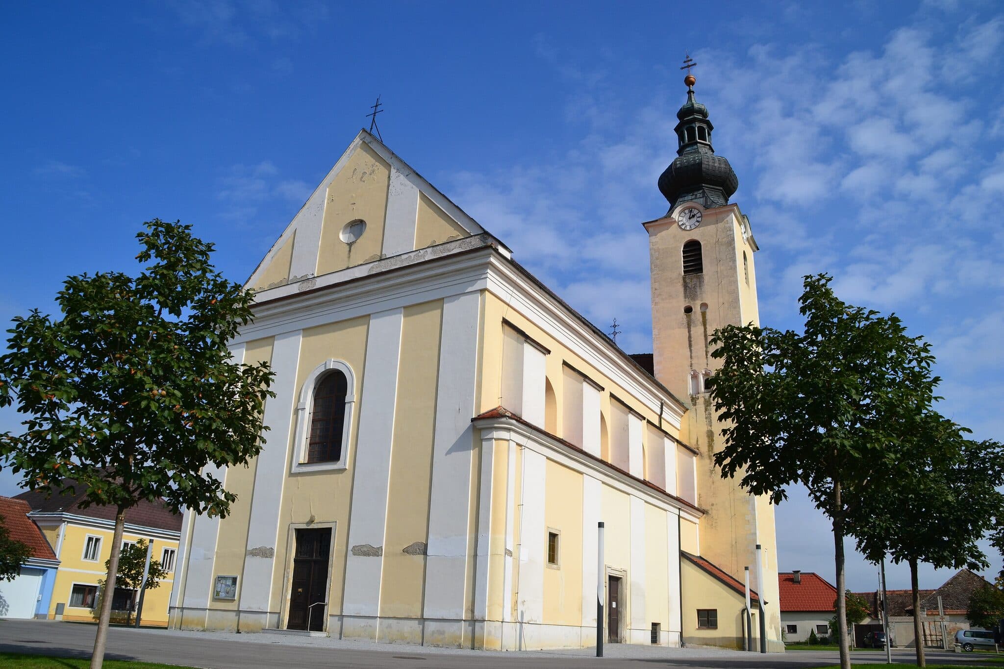 Pfarrkirche Stetteldorf am Wagram bei blauem Himmel mit umliegenden Dorfhaeusern